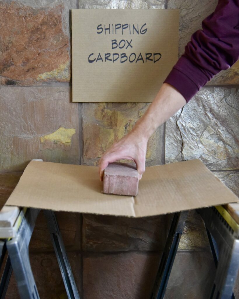 Regular shipping box cardboard crumpling with a single brick